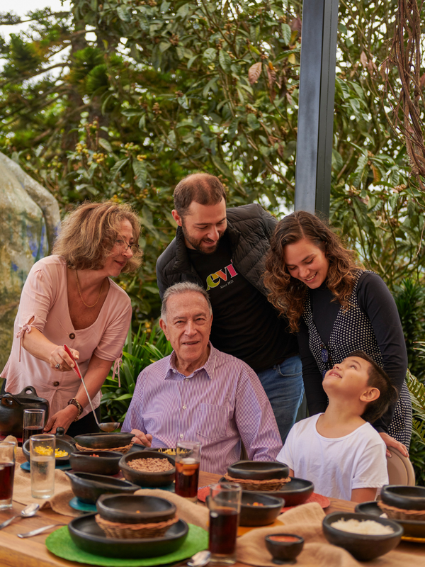 Papi autour à table avec ses enfants et petits enfants prêt pour faire une photo souvenir